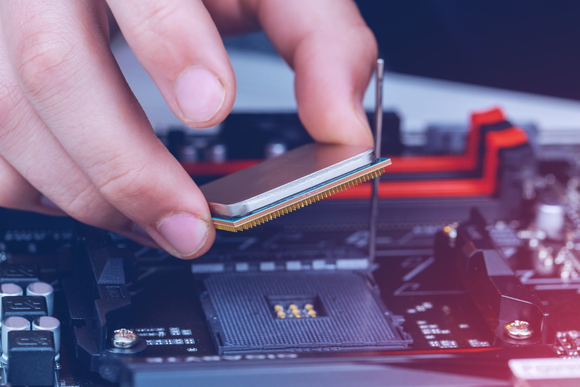 The technician installation of modern processor in CPU socket on the motherboard